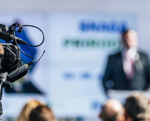 Media Event. Cameraman With Headphones Recording Speaker